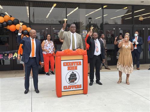 District officials and Principal Brown ring bells outside of Chester High School